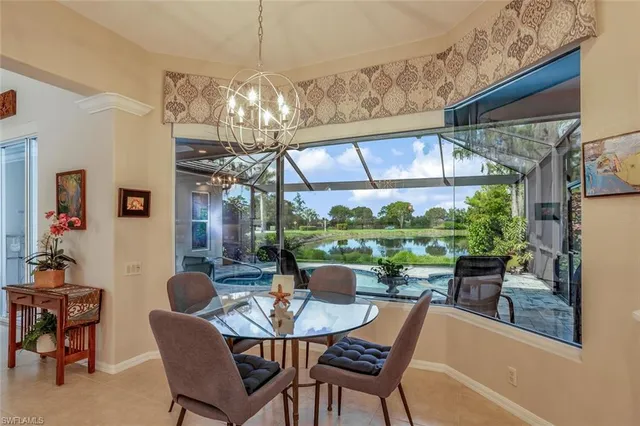 a view of a dining room with furniture a chandelier and large windows