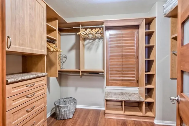 a view of walk in closet with clothes and shoes