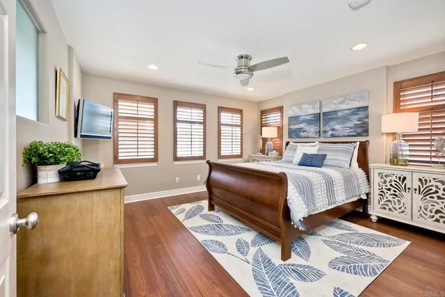 a bedroom with a bed wooden floor and window