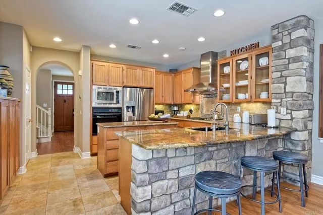 a kitchen with stainless steel appliances granite countertop a stove a sink and a refrigerator