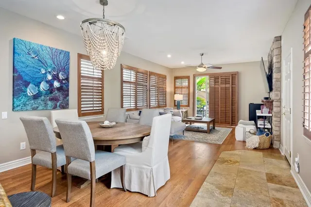 a dining room with furniture a chandelier and wooden floor