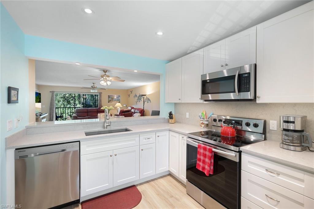 a kitchen with stainless steel appliances white cabinets sink and a microwave