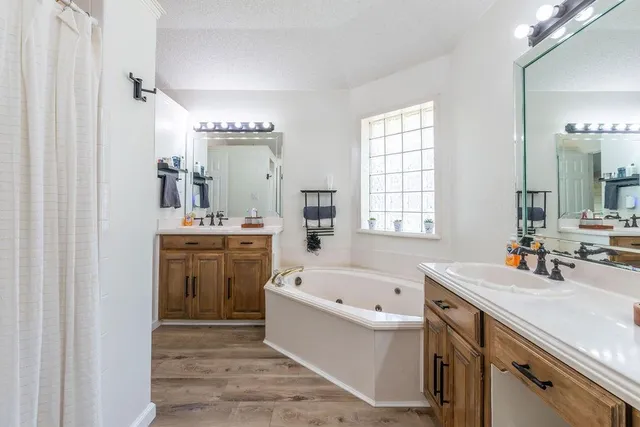 a bathroom with a tub sink and mirror