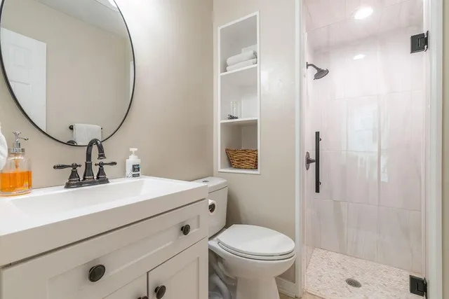 a bathroom with a sink a toilet and shower