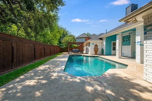 a view of a house with a small yard plants and large tree