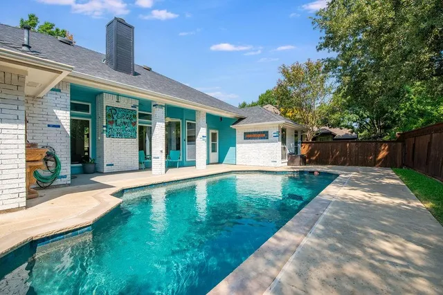 a view of pool with a yard and a large tree