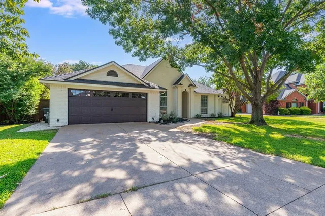 a front view of a house with a garden and trees