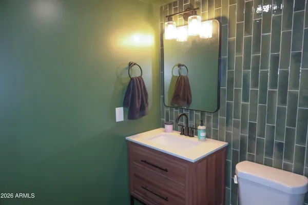 a bathroom with a sink vanity mirror and toilet