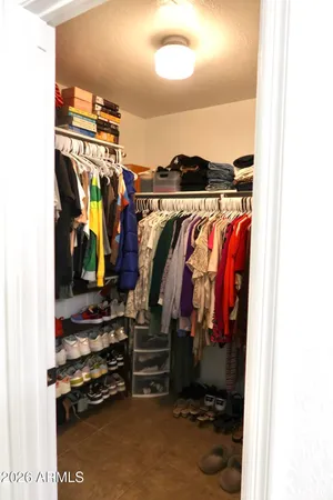 a view of walk in closet with clothes and shoes