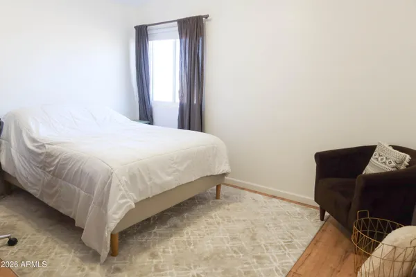 a large bed sitting in a bedroom next to a window with chair