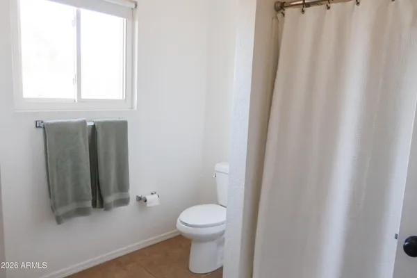 a bathroom with a toilet and a shower curtain