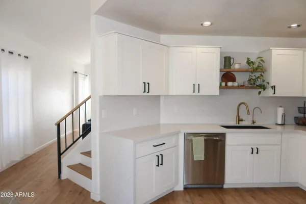a kitchen with granite countertop a sink a stove and cabinets
