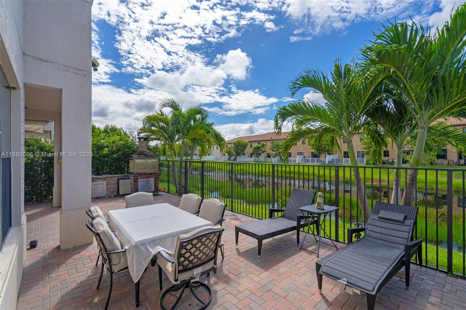 3332 West 95th Terrace, Unit 3332 Hialeah, FL 33018 - Photo 15 of 31 a patio with table and chairs potted plants and a palm tree