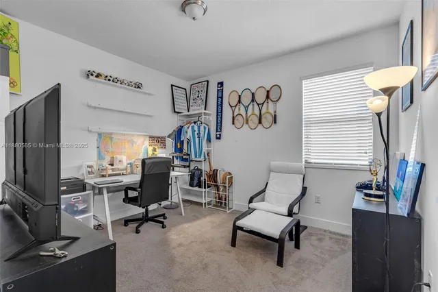 a view of a livingroom with workspace and a window