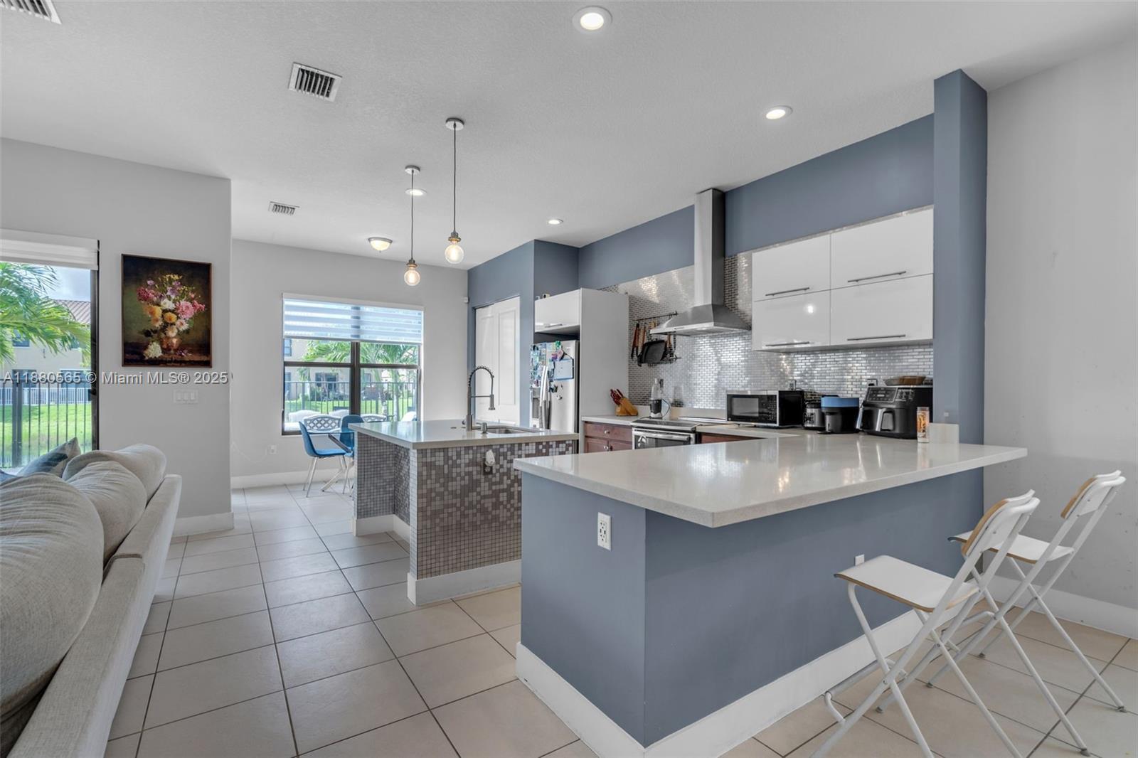 3332 West 95th Terrace, Unit 3332 Hialeah, FL 33018 - Photo 3 of 31 a kitchen with stainless steel appliances granite countertop a sink a stove and a refrigerator