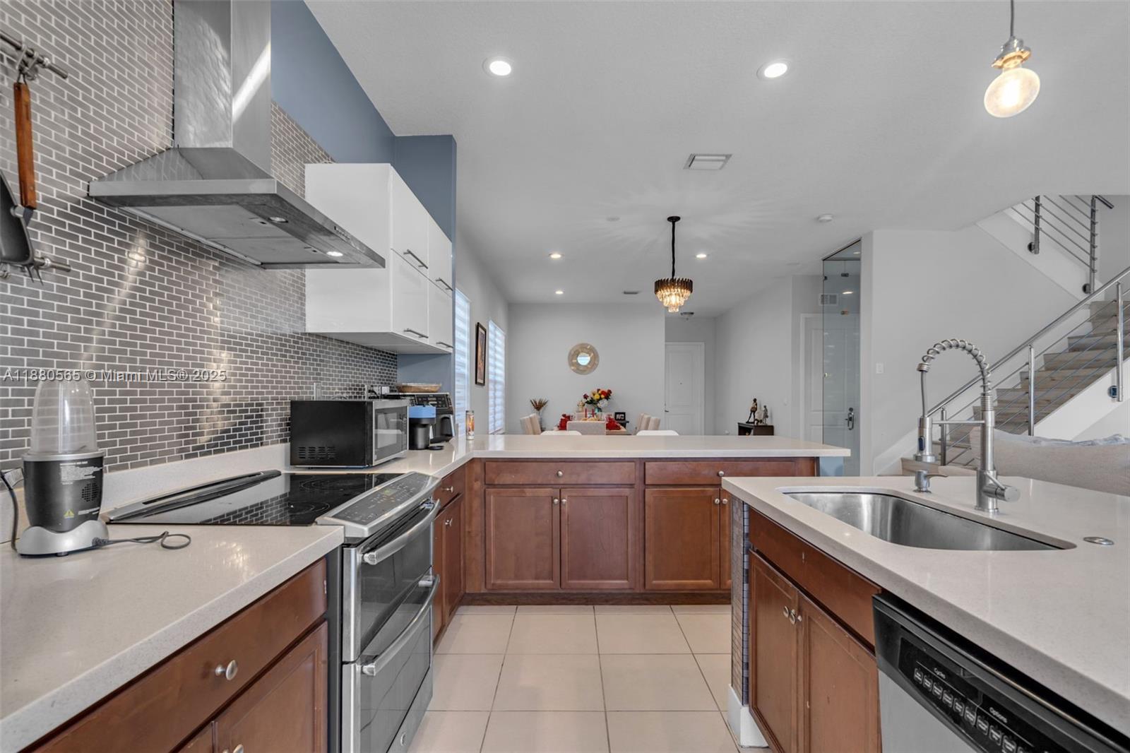 3332 West 95th Terrace, Unit 3332 Hialeah, FL 33018 - Photo 10 of 31 a kitchen with a sink stainless steel appliances and cabinets