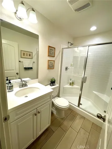 a bathroom with a double vanity sink toilet mirror and bathtub