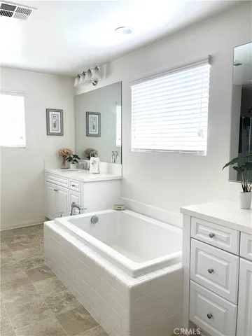 a spacious bathroom with a bathtub sink and mirror
