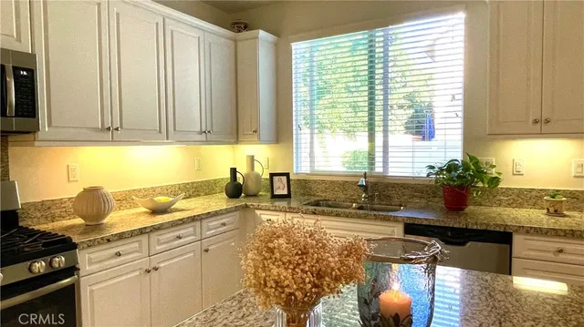 a kitchen with stainless steel appliances granite countertop a sink stove and cabinets