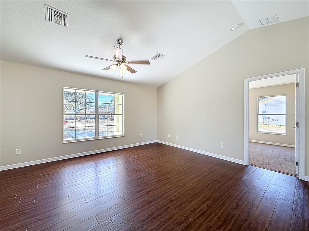 1314 Southwest 68th Avenue Bushnell, FL 33513 - Photo 16 of 33 a view of an empty room with wooden floor and a window