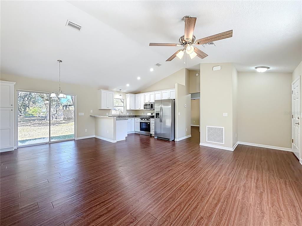 1314 Southwest 68th Avenue Bushnell, FL 33513 - Photo 17 of 33 a view of a kitchen with a fridge wooden floor and a ceiling fan