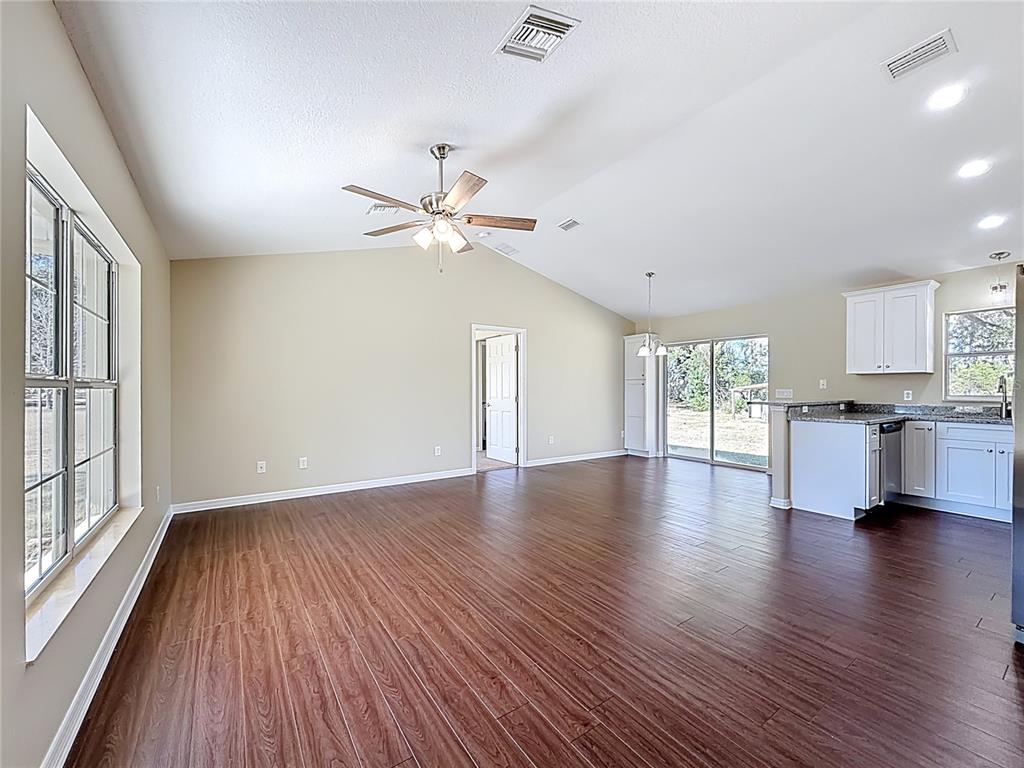 1314 Southwest 68th Avenue Bushnell, FL 33513 - Photo 18 of 33 a view of an empty room with wooden floor and a window
