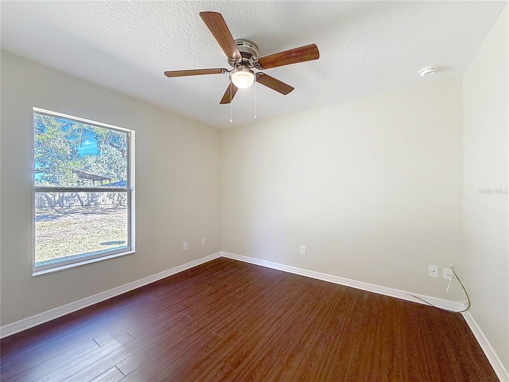 1314 Southwest 68th Avenue Bushnell, FL 33513 - Photo 28 of 33 a view of an empty room with wooden floor and a window