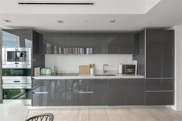 a kitchen with stainless steel appliances granite countertop a refrigerator a stove and a sink with wooden cabinets