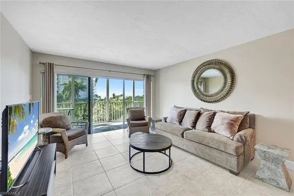a living room with furniture a floor to ceiling window and a large window