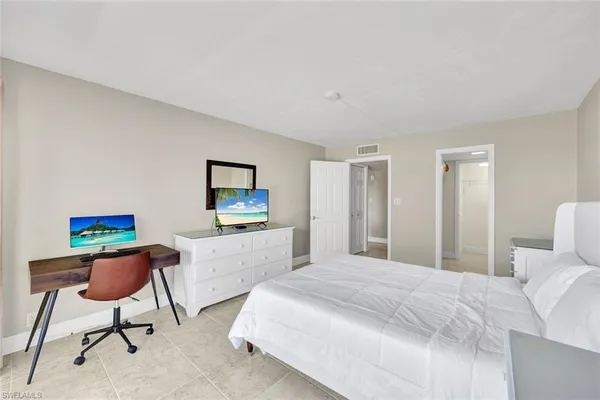 a bedroom with furniture and a flat screen tv