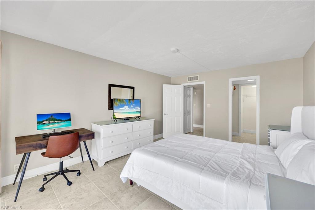 1 Bluebill Avenue, Unit 409 Naples, FL 34108 - Photo 10 of 25 a bedroom with a bed and a chair