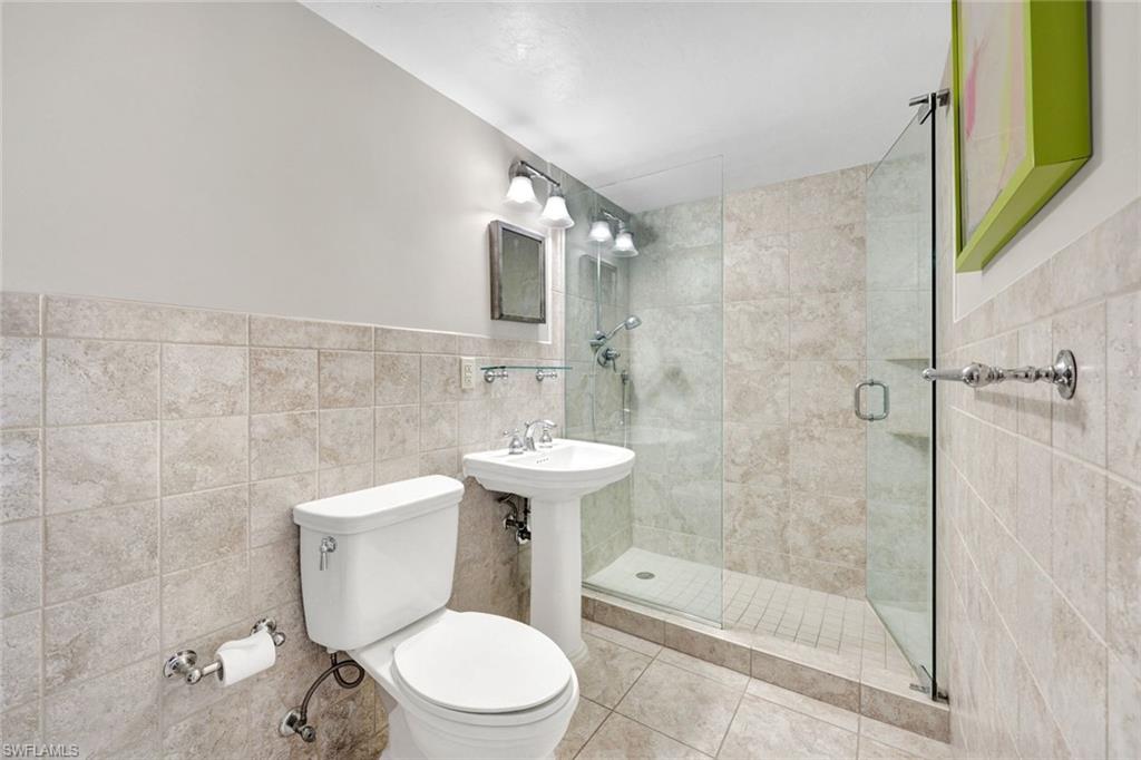 1 Bluebill Avenue, Unit 409 Naples, FL 34108 - Photo 11 of 25 a bathroom with a sink a toilet and shower
