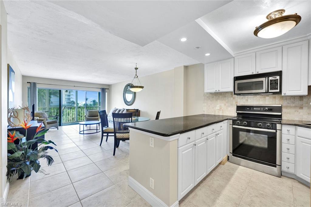 1 Bluebill Avenue, Unit 409 Naples, FL 34108 - Photo 4 of 25 a kitchen with granite countertop a sink and a stove top oven
