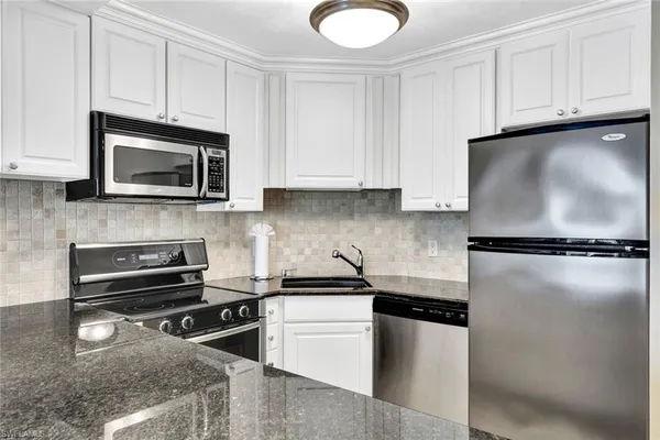 a kitchen with a refrigerator stove and microwave