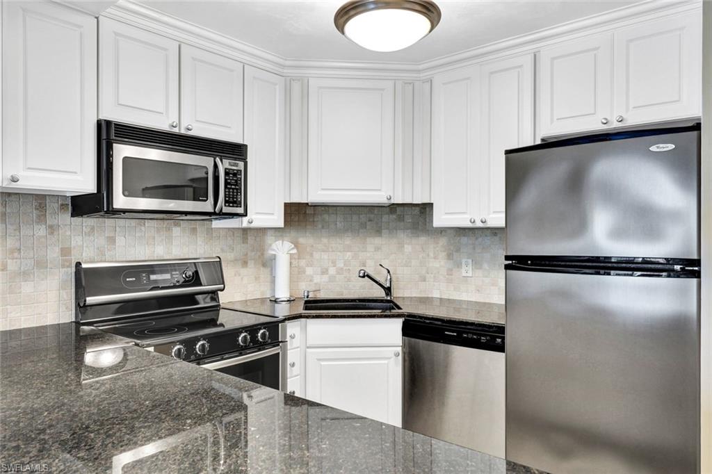 1 Bluebill Avenue, Unit 409 Naples, FL 34108 - Photo 6 of 25 a kitchen with a refrigerator stove and microwave