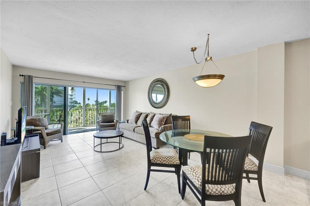 1 Bluebill Avenue, Unit 409 Naples, FL 34108 - Photo 7 of 25 a view of a dining room with furniture window and outside view