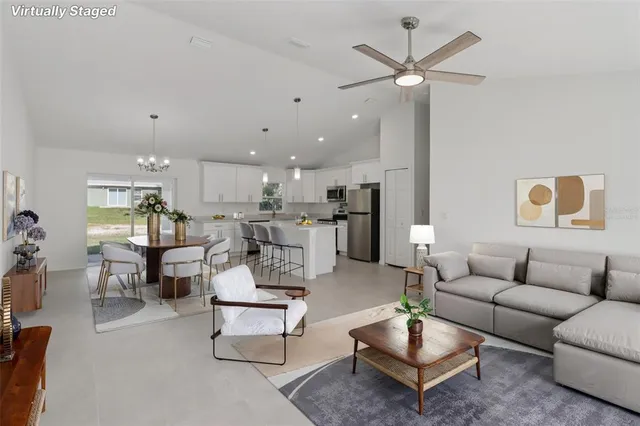 a living room with furniture kitchen view and a table