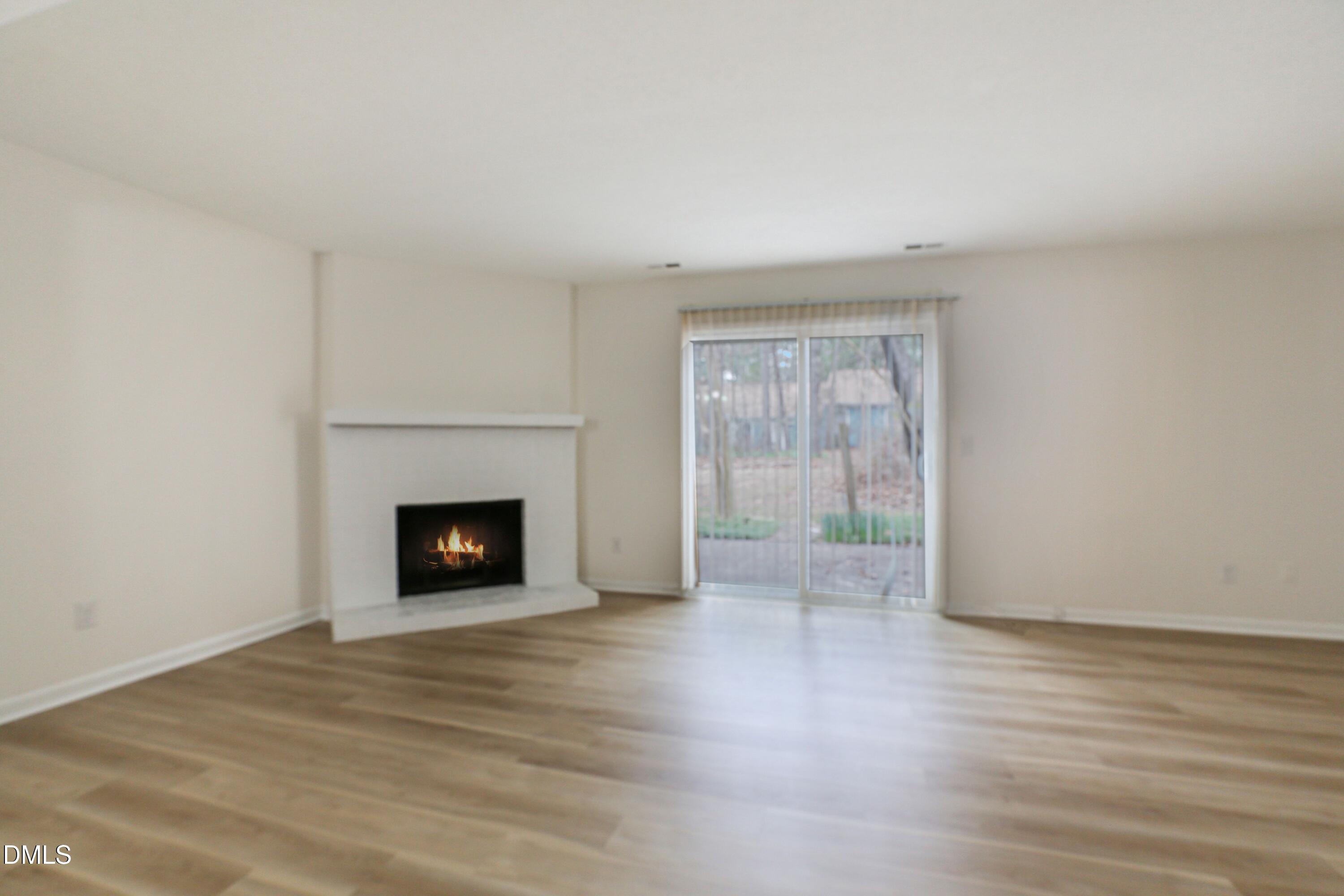 1304 Seaton Road, Unit 30 Durham, NC 27713 - Photo 12 of 25 a view of an empty room with wooden floor fireplace and a window