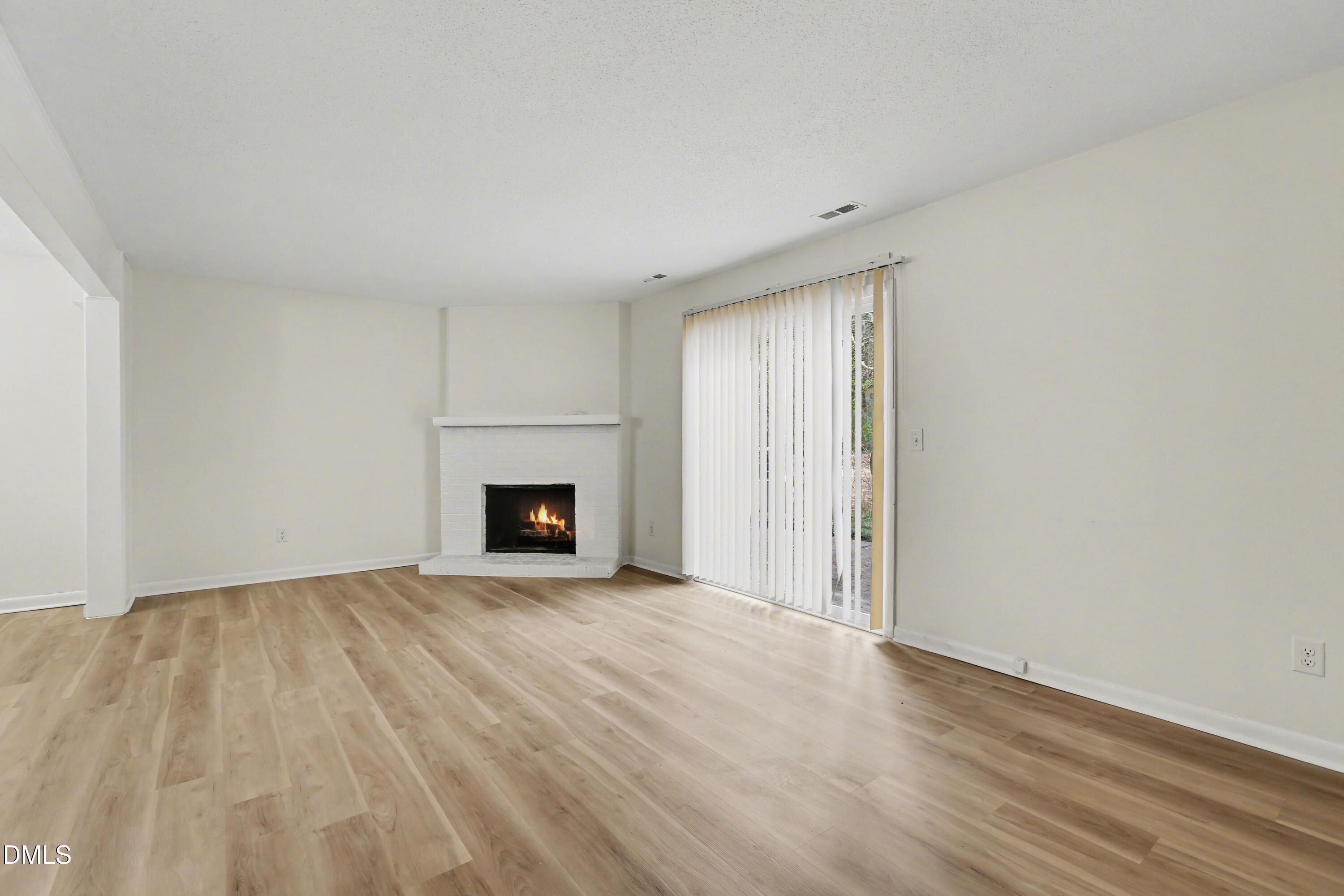 1304 Seaton Road, Unit 30 Durham, NC 27713 - Photo 13 of 25 a view of an empty room with wooden floor and a fireplace