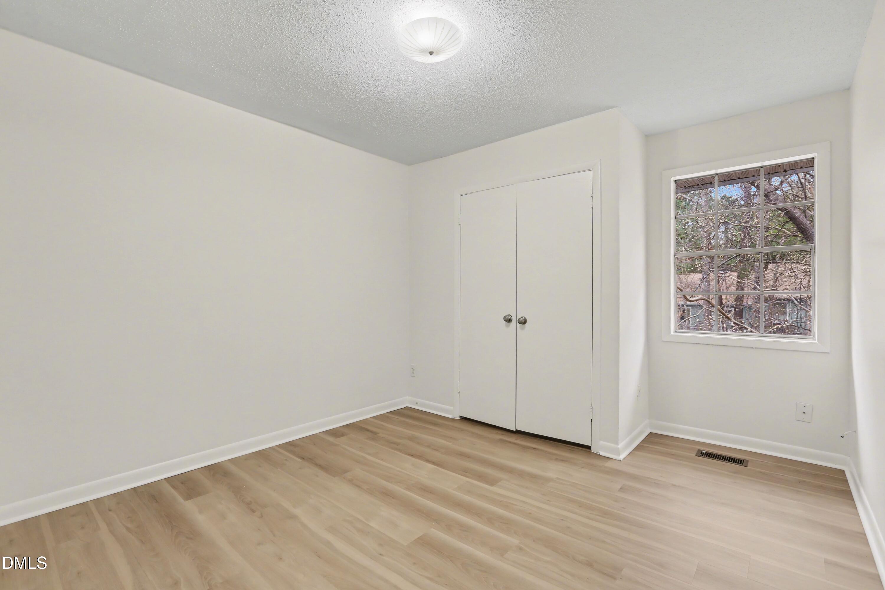 1304 Seaton Road, Unit 30 Durham, NC 27713 - Photo 17 of 25 an empty room with wooden floor and windows