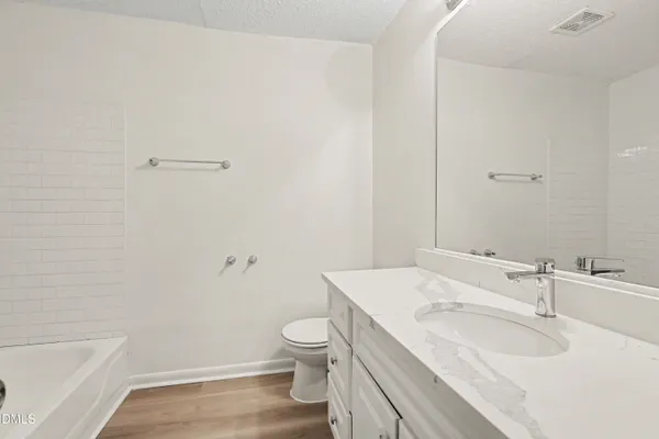 an empty room with wooden floor chandelier fan and windows