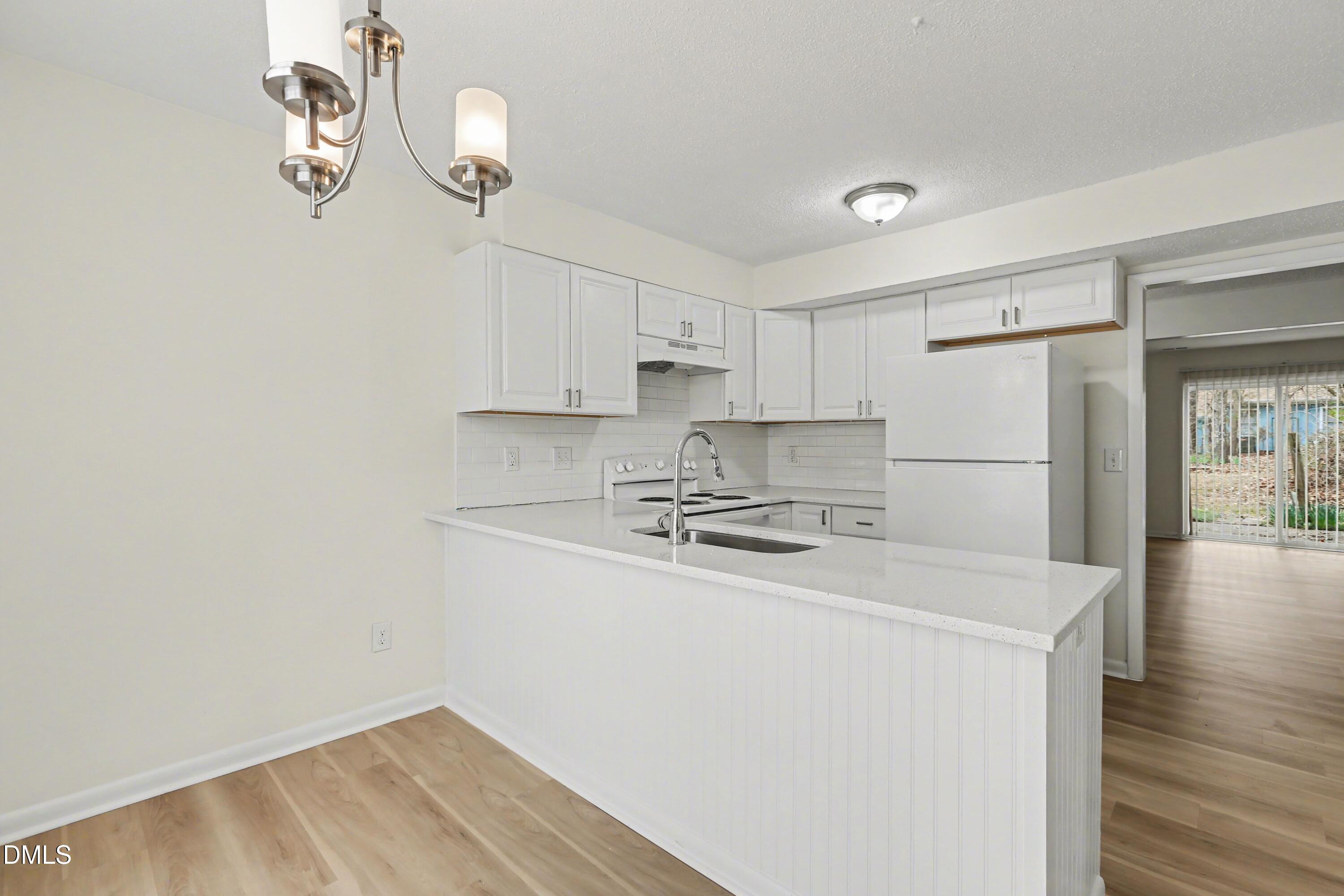 1304 Seaton Road, Unit 30 Durham, NC 27713 - Photo 7 of 25 a kitchen with a refrigerator a stove cabinets and wooden floor