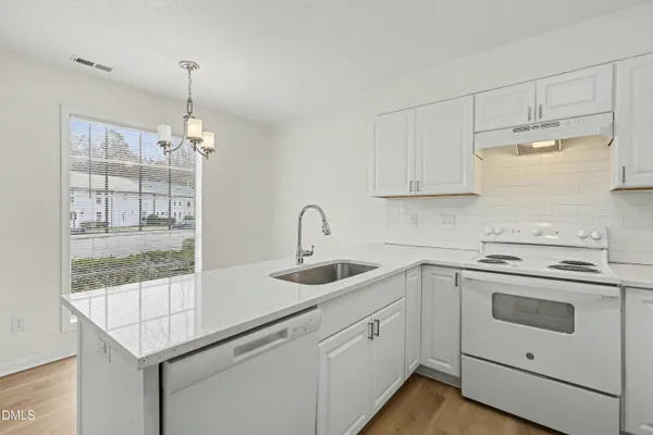 a kitchen with a sink and chandelier