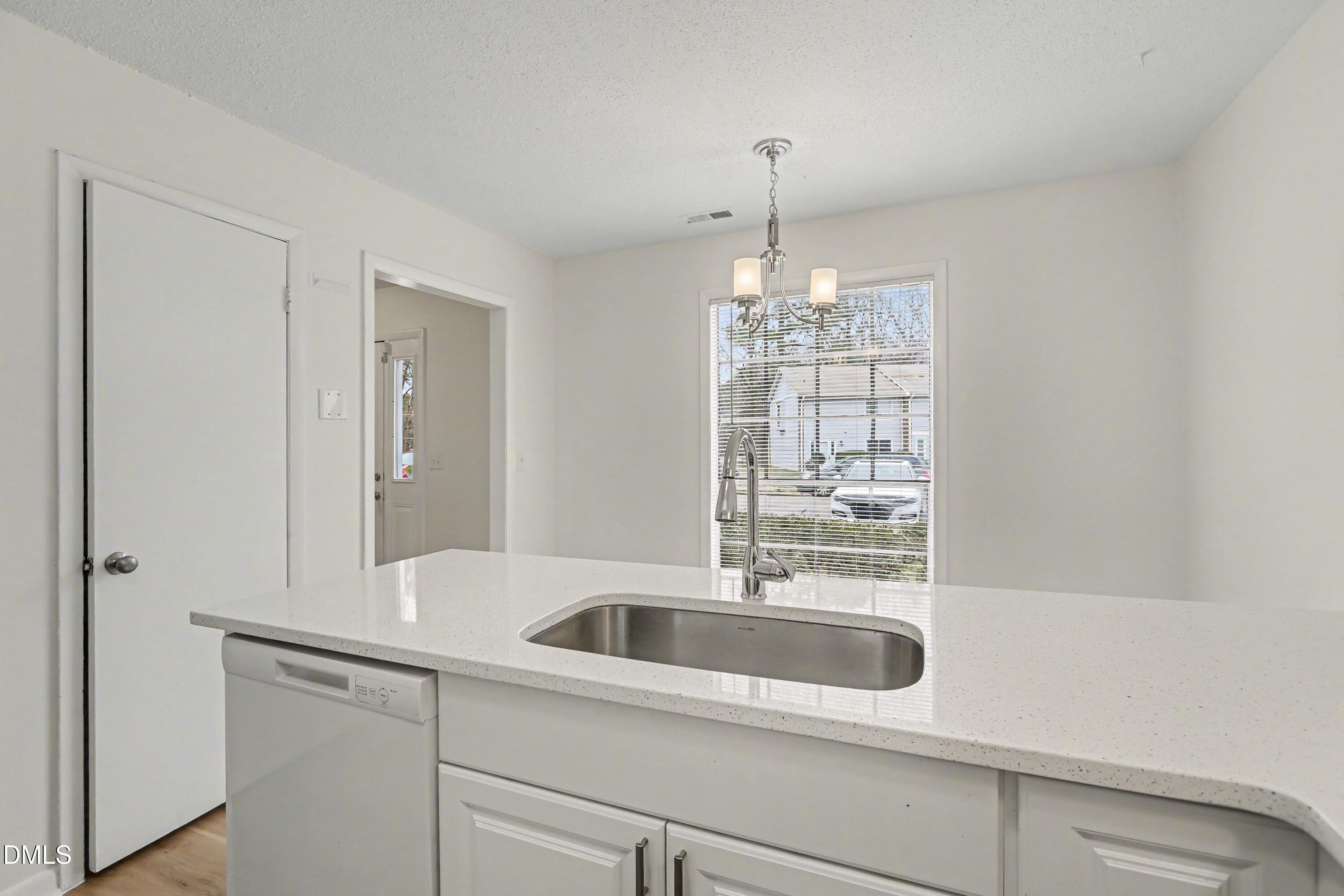 1304 Seaton Road, Unit 30 Durham, NC 27713 - Photo 9 of 25 a kitchen with a sink and chandelier