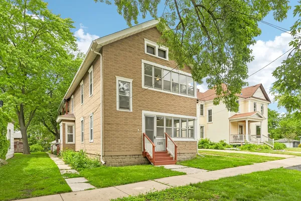 a front view of a house with a yard and trees