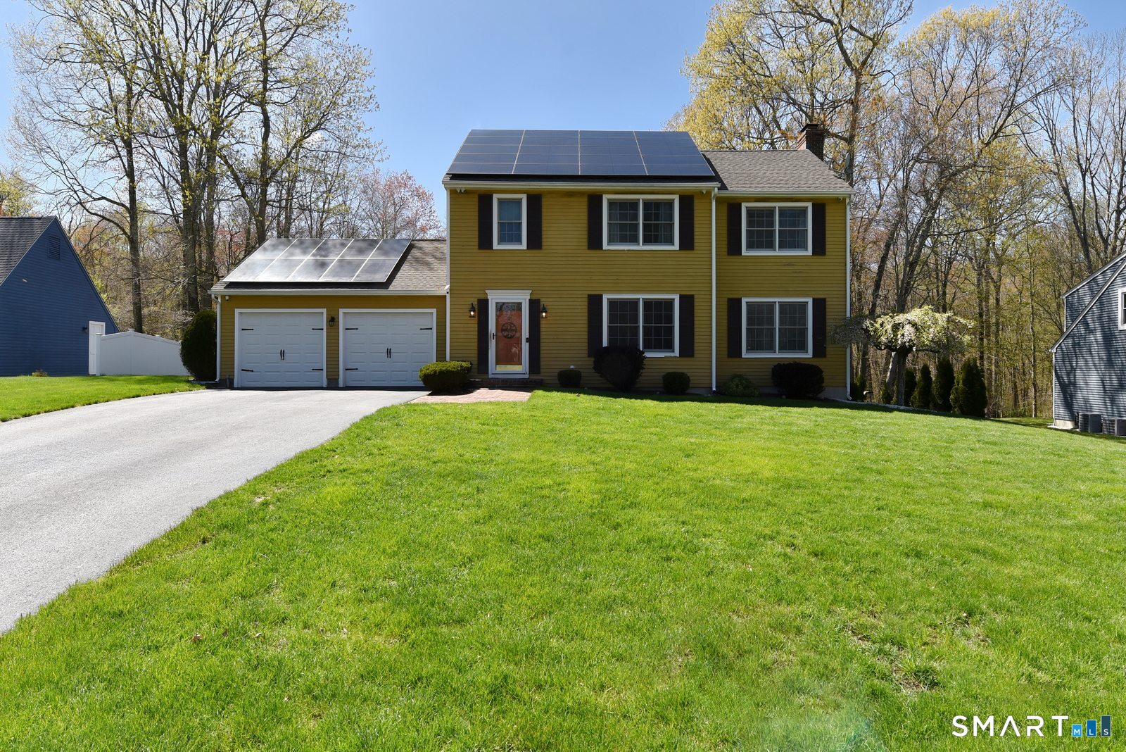 a front view of a house with yard and green space