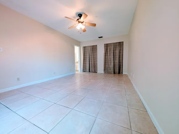 a view of an empty room with a chandelier fan