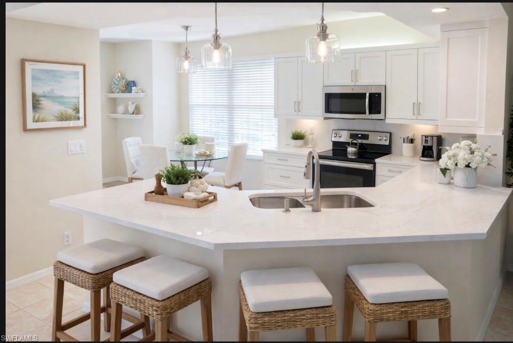 10911 Oak Island Road, Unit 201 Estero, FL 34135 - Photo 18 of 24 a kitchen with stainless steel appliances a sink a stove a table and chairs