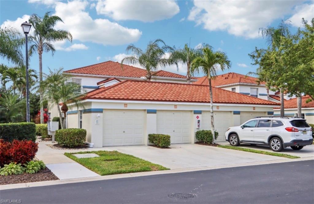 10911 Oak Island Road, Unit 201 Estero, FL 34135 - Photo 19 of 24 a front view of a house with a yard and garage