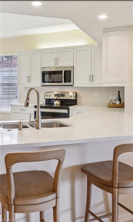 10911 Oak Island Road, Unit 201 Estero, FL 34135 - Photo 4 of 24 a kitchen with a dining table chairs and a refrigerator